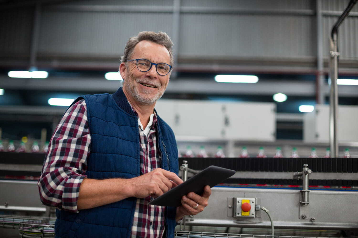 Operator with a tablet next to a bottling line