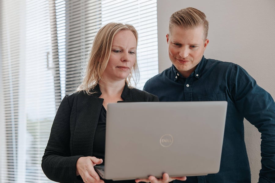 Colleagues going through work together on a laptop