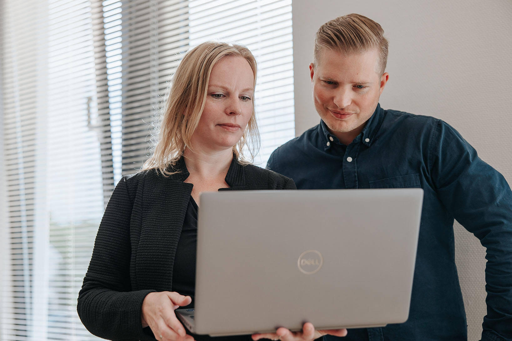 Two EZ Factory colleagues looking at a laptop together at the office